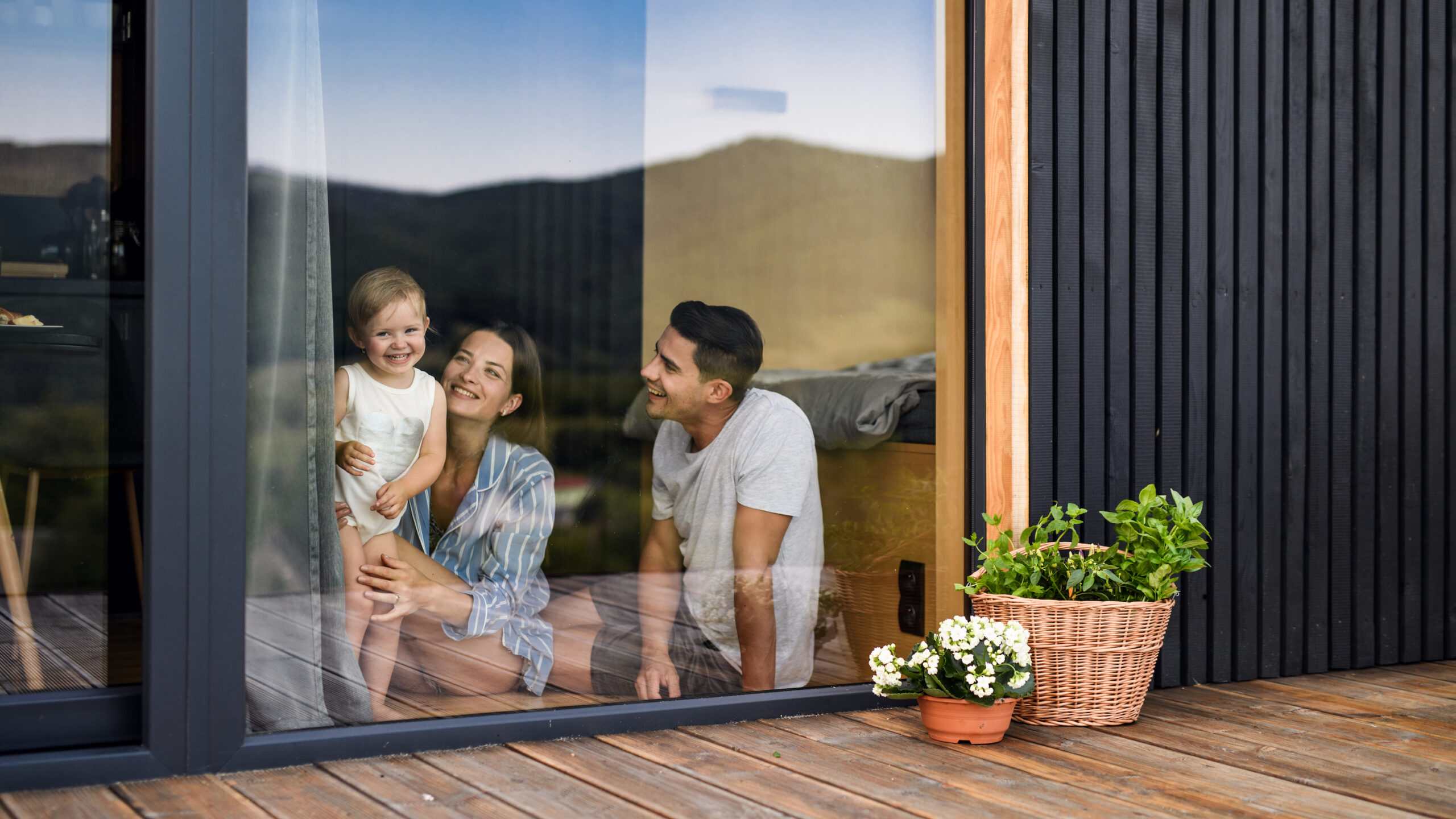 Family looking outside through a window in summer.